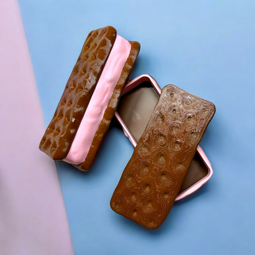 Two brown textured ice cream sandwiches with pink and white filling on a light blue background.