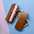 Two brown textured ice cream sandwiches with pink and white filling on a light blue background.