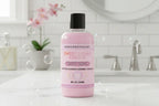 Pink bottle of 'Sweet Sugar Cookie' body wash with black cap on white background